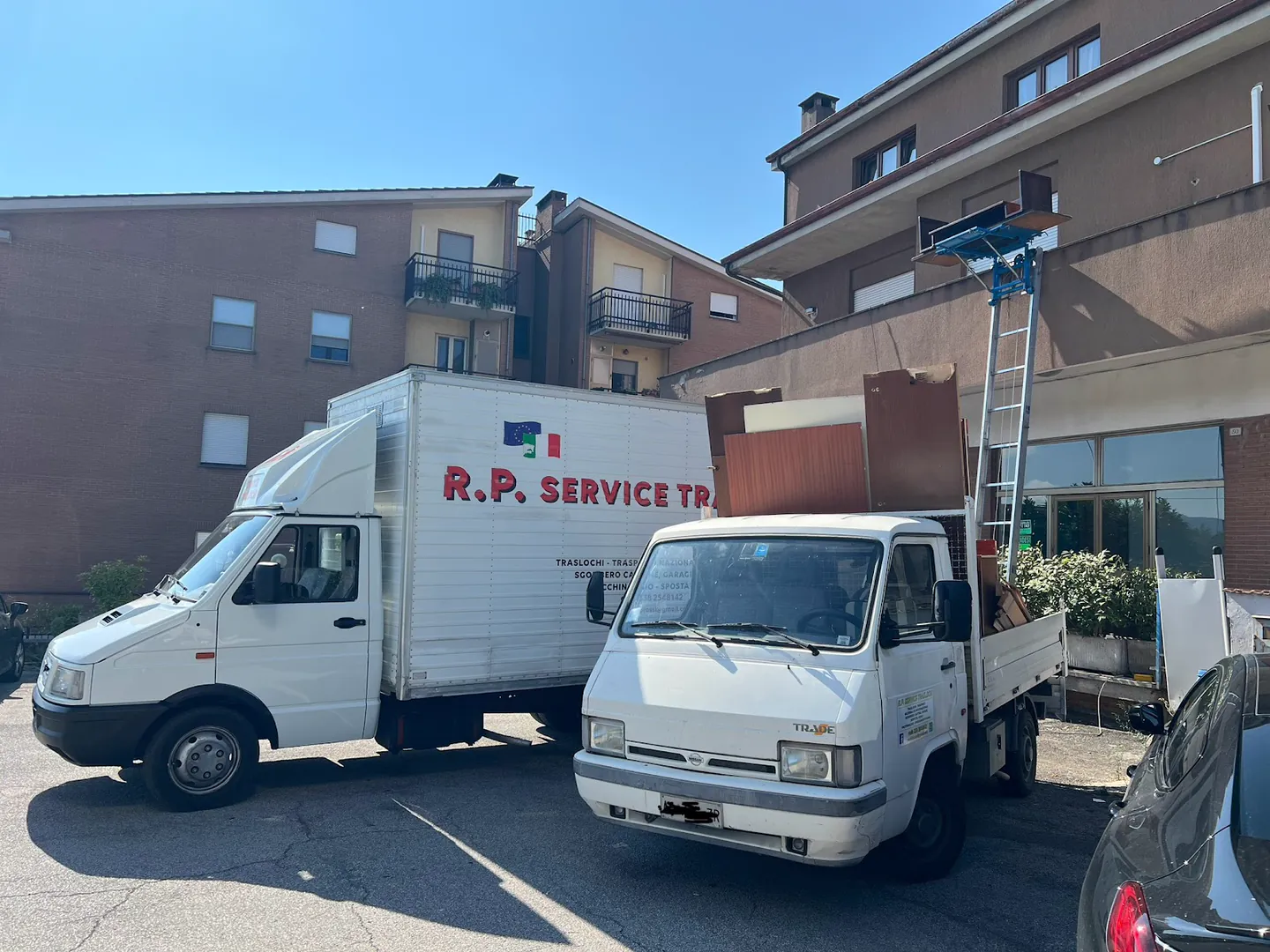 I mezzi di R.P. Traslochi con il montacarichi davanti a un palazzo